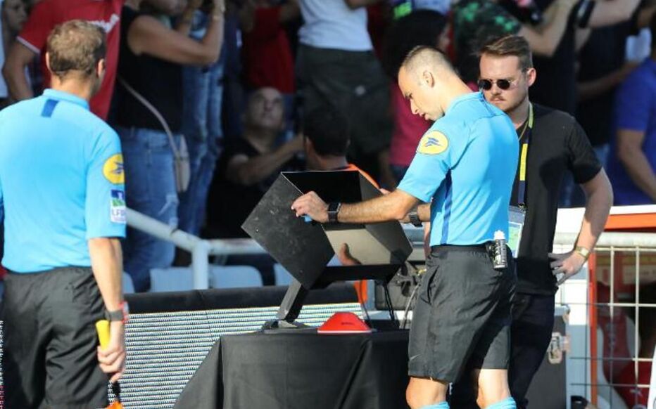 Arbitre de Ligue 1 consultant la VAR